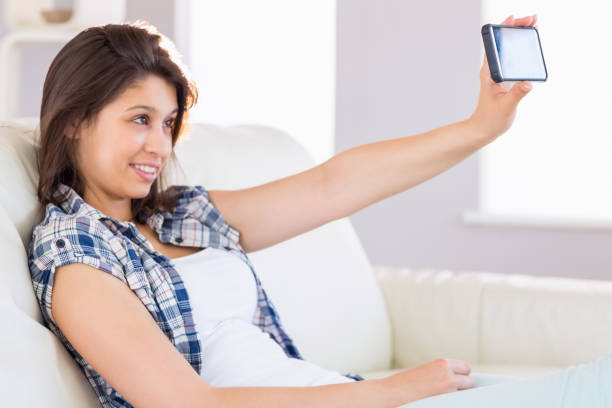 istock Pretty brunette taking a selfie on couch 817209334