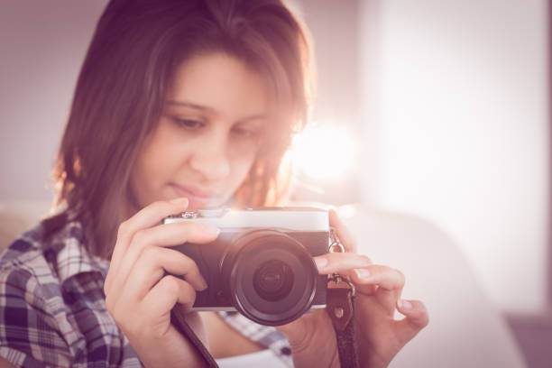 istock Pretty brunette looking at retro camera on couch 817213712