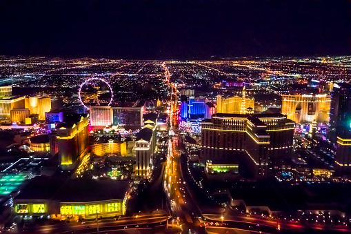 Aerial shot of Las Vegas taken in the evening. All logos removed. Vibrant multi colored lights are glowing against a black evening sky. Taken with Canon 5D Mark lV.