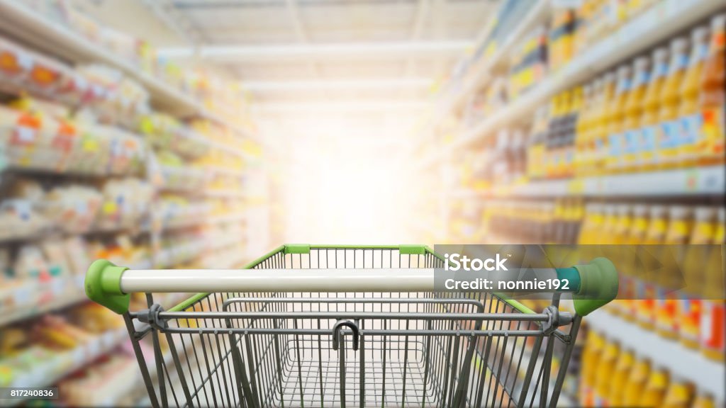 Supermarket aisle with empty green shopping cart Supermarket Stock Photo