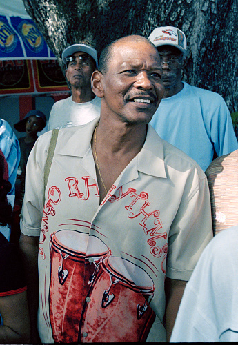 On Carnival Tuesday in Port of Spain, Trinidad, near the large park called the Savannah, tourists and local people watch the bands organize and march past. Sometimes the onlookers spend as much energy as the participants in looking good as does the man with his exceptionally well-ironed shirt.