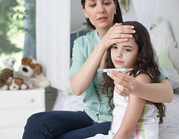 giovane donna in camera da letto che ragazze temperatura - child fever illness thermometer foto e immagini stock