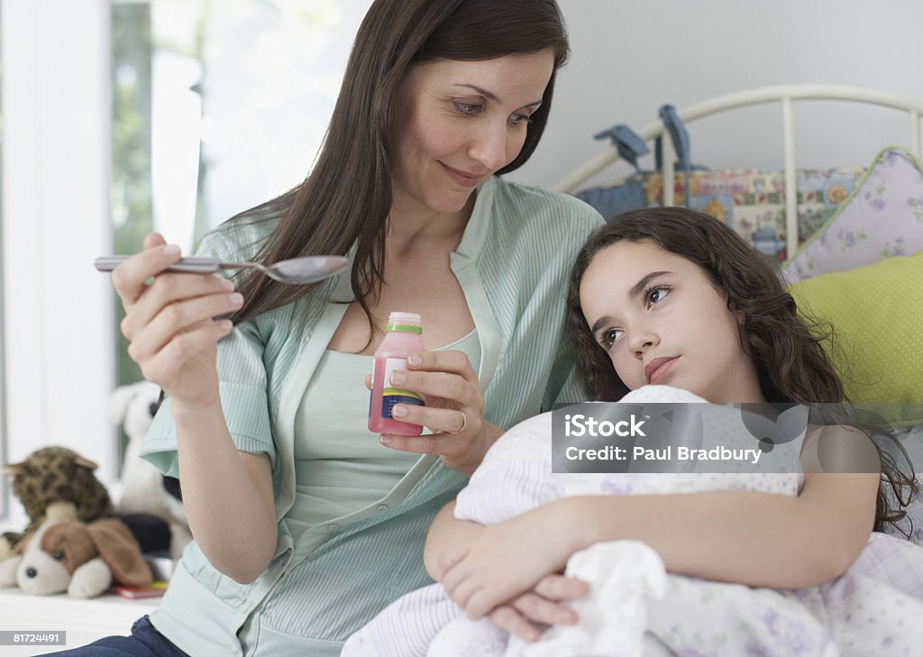 Chica joven mujer ayudando a tomar el medicamento en el dormitorio - Foto de stock de Hija libre de derechos