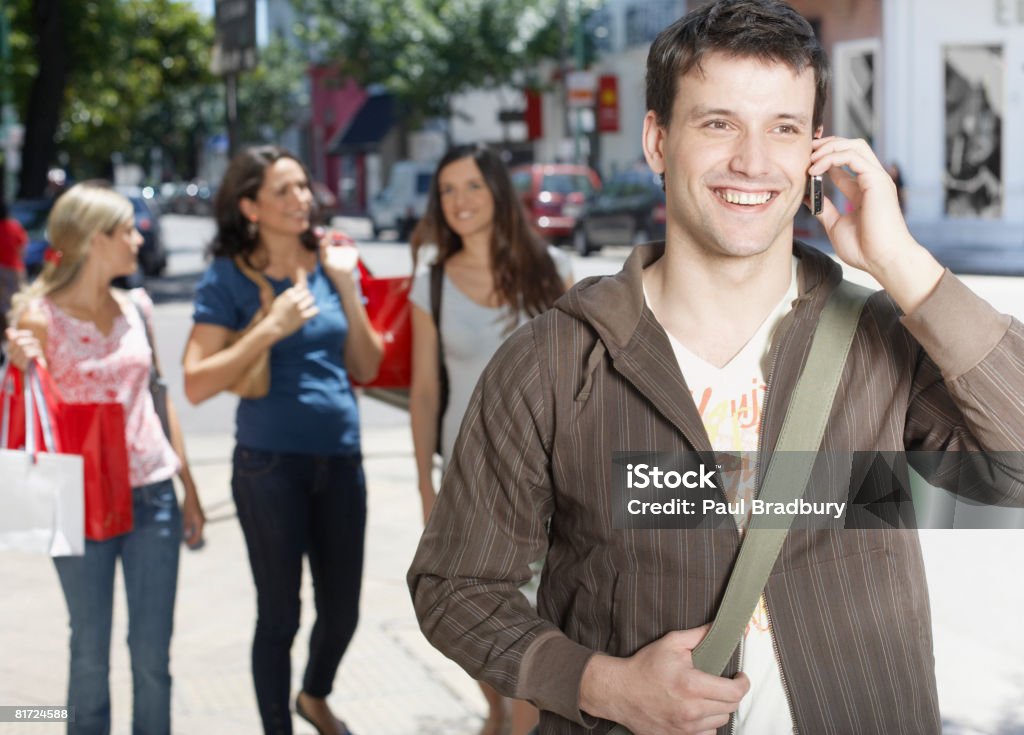 Homem ao ar livre, usando telefone celular e sorrindo - Foto de stock de 20 Anos royalty-free