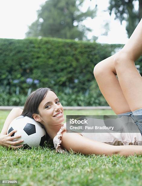 Mulher Ao Ar Livre Em Repouso Com Cabeça De Bola De Futebol Sorridente - Fotografias de stock e mais imagens de 20-24 Anos