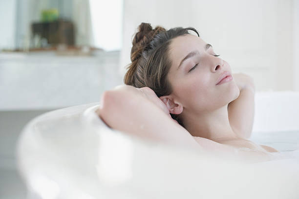 mulher relaxando no banho de espuma - bathtub women relaxation bathroom - fotografias e filmes do acervo