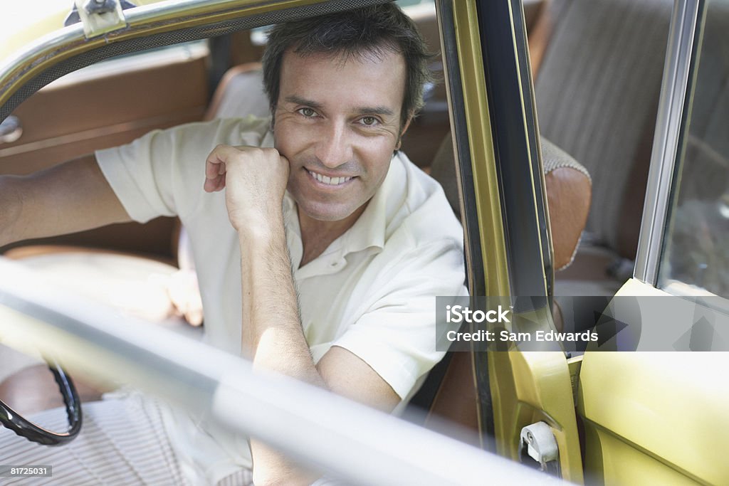Homme assis en place du conducteur de la voiture souriant - Photo de 45-49 ans libre de droits