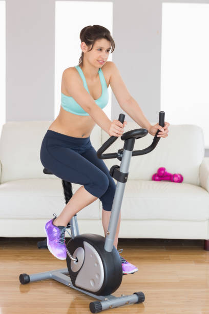 istock Fit brunette working out on exercise bike 817251544