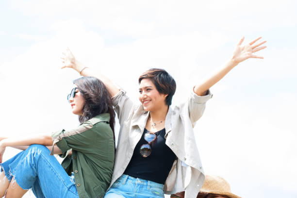 Two woman are enjoy her trip happily with sky background