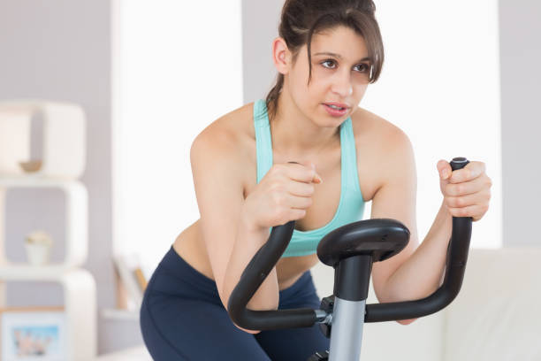 istock Fit brunette working out on exercise bike 817254368