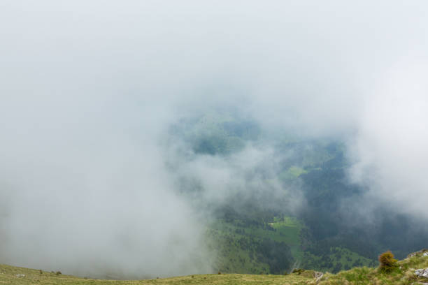 istock Limestone cliffs covered in fog and clouds in the Alps 817263466