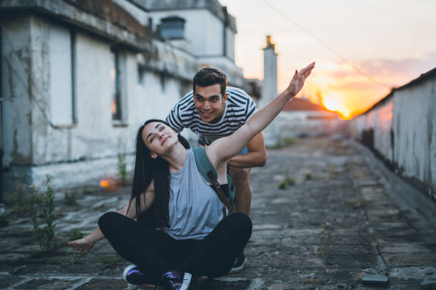 istock Guy pushing girl on skateboard 817290122