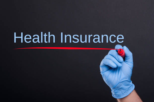 istock Health insurance text written by doctor hand 817298106