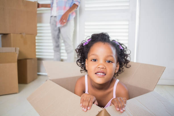 istock Cute daughter sitting in moving box 817298650