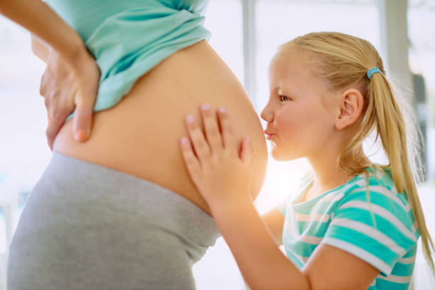 Pregnant woman pointing at her belly with a speech bubble