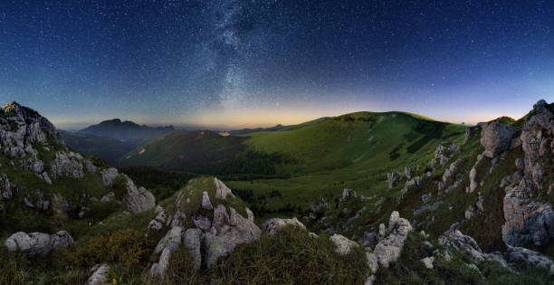 istock Milky way over green valley mountain 817307054