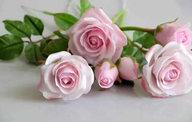 Wonderful clay art with pink roses flower relect on white background, beautiful artificial flowers of craftsmanship with skillful