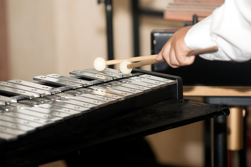 Vibraphone keyboard close-up side view ,metal bars and musician's hands with his drumsticks