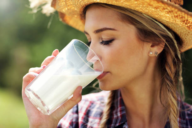 mujer joven con leche orgánica - mujer bebiendo leche fotografías e imágenes de stock