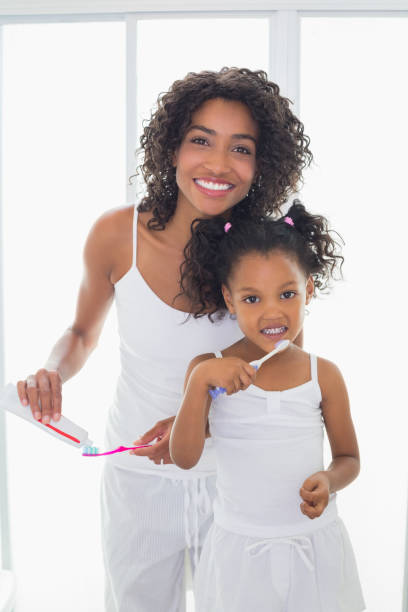 istock Pretty mother with her daughter brushing their teeth 817318458