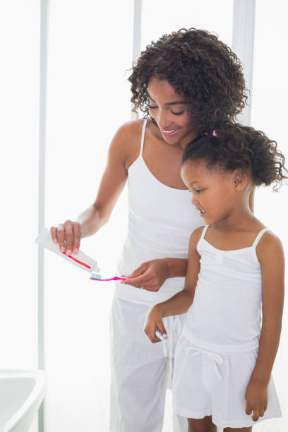 istock Pretty mother with her daughter brushing their teeth 817318526