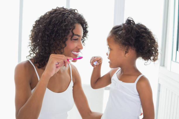 그들의 솔 질 하는 그녀의 딸과 함께 예쁜 어머니 - brushing teeth brushing dental hygiene human teeth 뉴스 사진 이미지