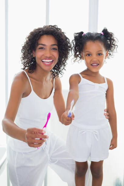 istock Pretty mother and daughter holding toothbrushes 817318724