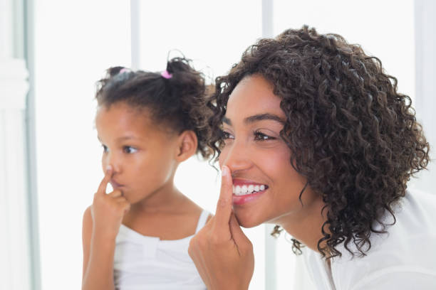 istock Pretty mother putting face cream on with her daughter 817321656