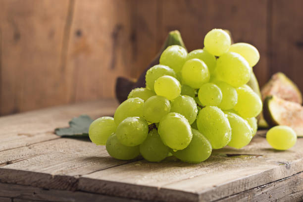green grapes with ripe figs fruit on wooden background. - table grape imagens e fotografias de stock