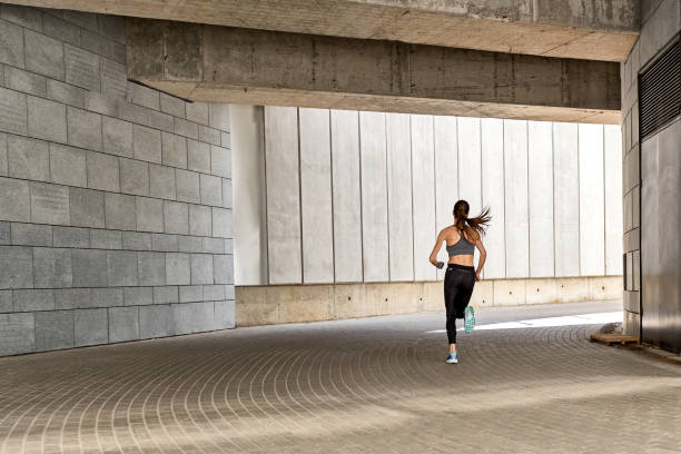 istock Cheerful young woman running at stadium 817322088