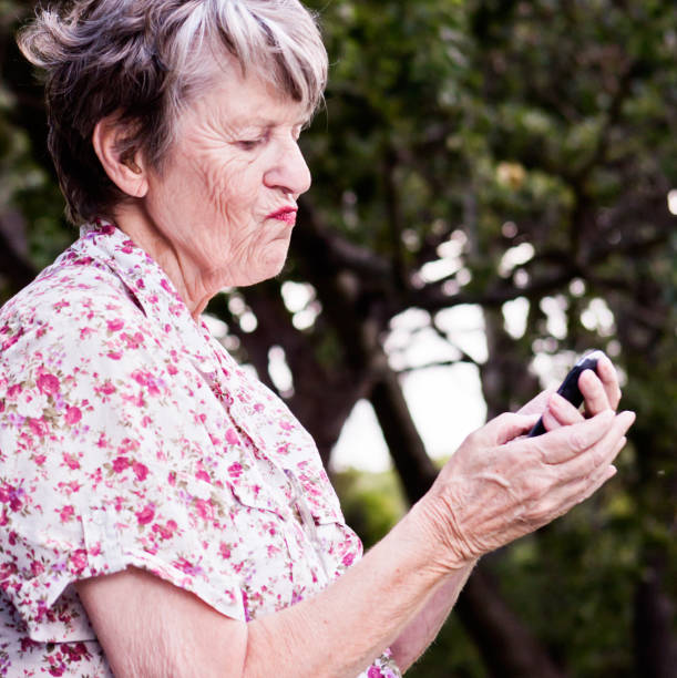 istock Old woman battling with modern technology: problems with mobile phone 817325336