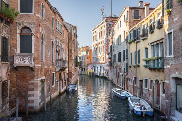 Canal with boats and historical buildings in Venice, Italy. stock photo