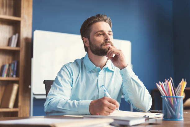 istock Thoughtful youthful bearded guy doing test for job employment 817327792