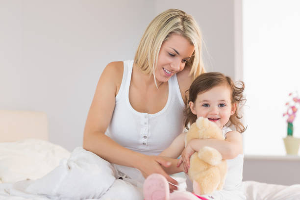 istock Relaxed mother and daughter sitting on bed 817327834