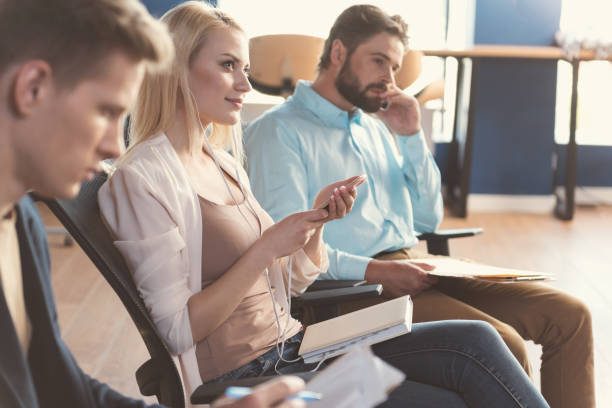 istock Cheery lady and serious men waiting in job talk queue 817328596