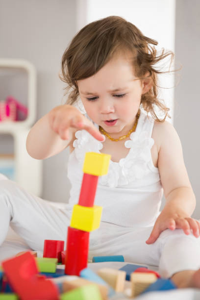 istock Cute girl playing with building blocks on bed 817331506