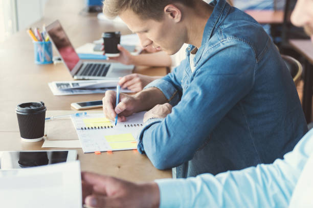 istock Pensive youthful guy working together with colleagues in office room 817332124