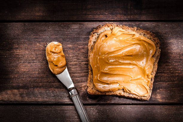 istock Peanut butter on toast shot on rustic wooden table 817334776