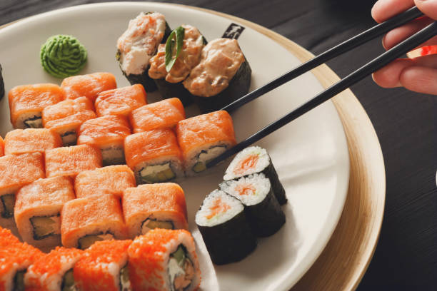 istock Eating sushi and rolls in japanese restaurant 817335118