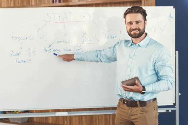 istock Cheery youthful bearded guy telling about job strategy at work 817338668