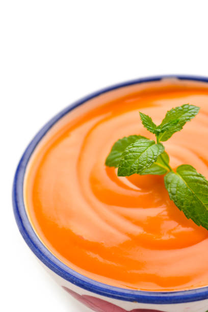 closeup of a ceramic bowl with spanish salmorejo cordobes or porra antequerana, a cold tomato soup, on a white background