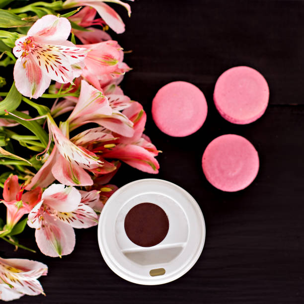 Classic French macaroons on a black background. Colorful macaroon close up on a black background. macaroon and flowers on dark   background