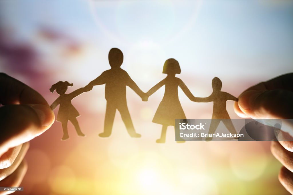 Paper chain family Paper chain family held up to sunset Family Stock Photo