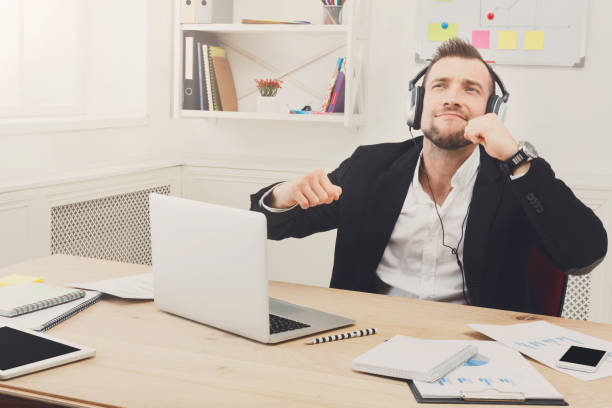 istock Young businessman listen music in modern white office 817348538