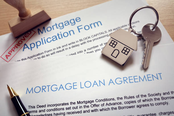 Mortgage application loan agreement and house key Mortgage loan agreement application with  key on house shaped keyring mortgages and loans stock pictures, royalty-free photos & images