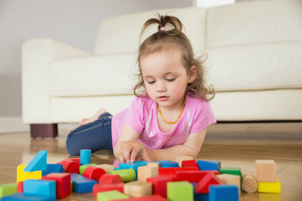 istock Girl playing with building blocks on floor 817351678