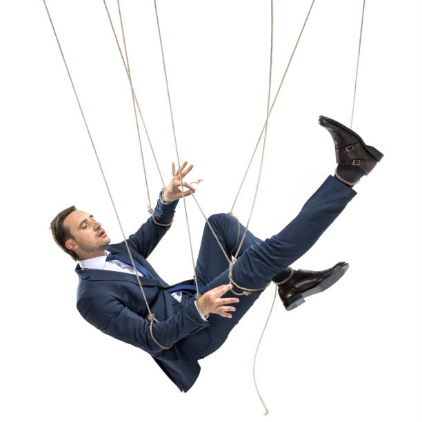 istock businessman trying to break free while hanging on manipulating ropes isolated on white 817355218