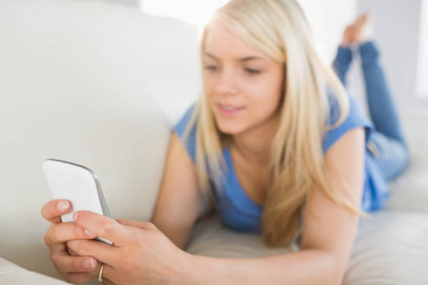 istock Relaxed woman text messaging in living room 817355332
