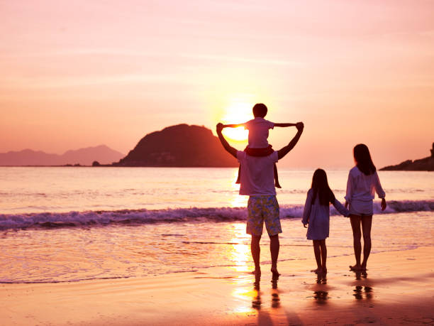 familia asiática viendo amanecer en la playa - holding hands child silhouette family fotografías e imágenes de stock