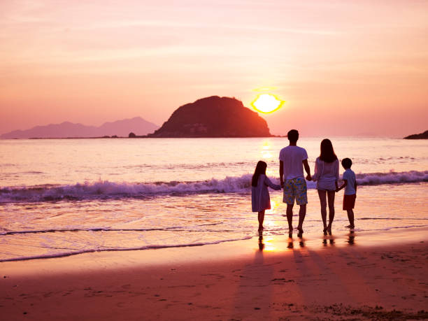 istock asian family watching sunrise on beach 817359082